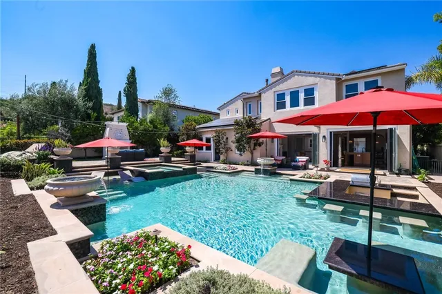 a backyard of a house with yard fountain and outdoor seating