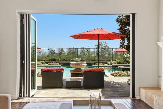 a large kitchen with stainless steel appliances granite countertop a stove top oven a refrigerator a dining table and chairs with wooden floor