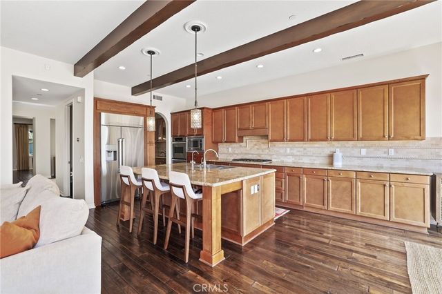 a kitchen with stainless steel appliances granite countertop a lot of counter space and wooden floors
