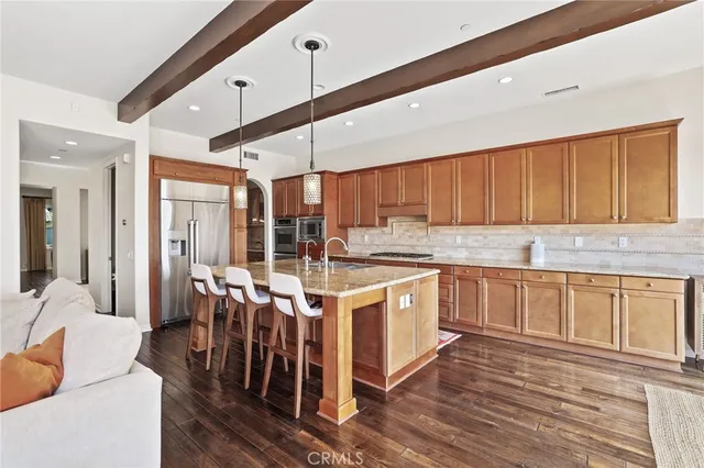 a kitchen with stainless steel appliances granite countertop a lot of counter space and wooden floors