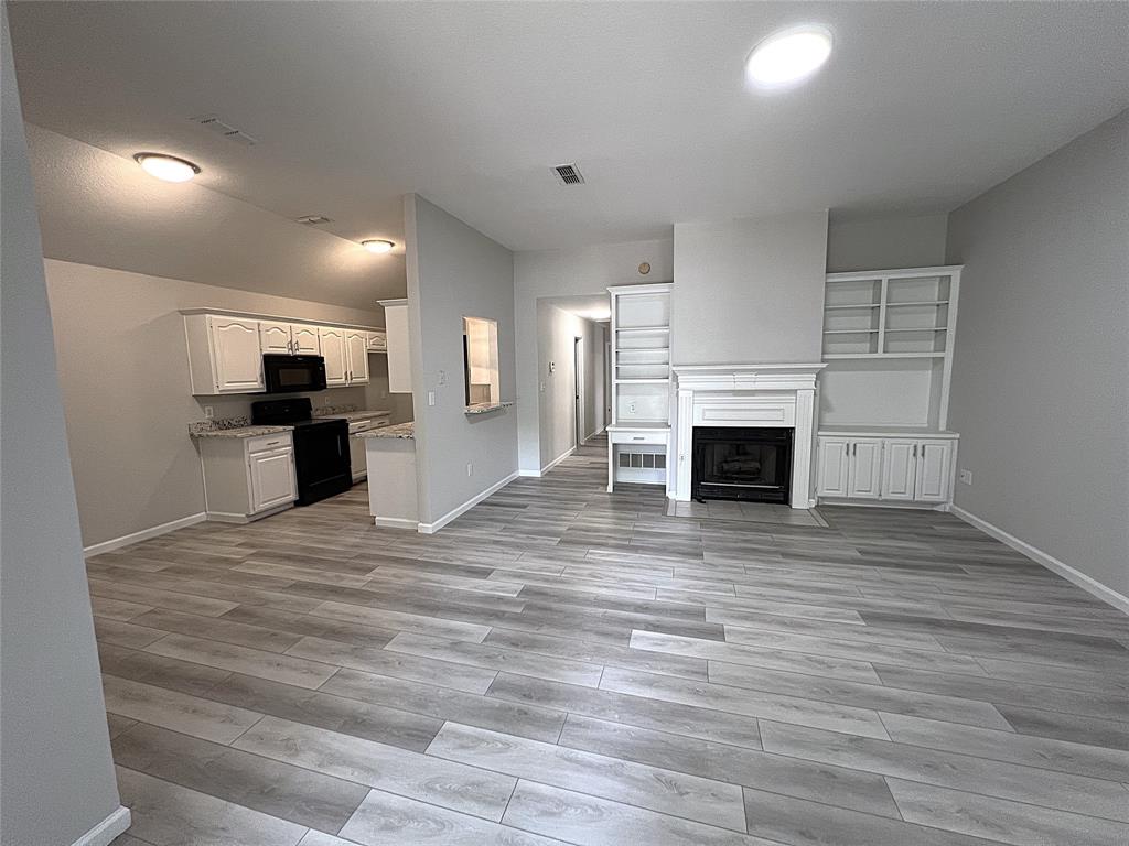 902 Mack Place Denton, TX 76209 - Photo 2 of 11 a view of a kitchen with a stove cabinets and wooden floor