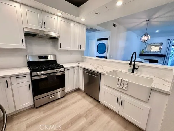 a kitchen with white cabinets and appliances