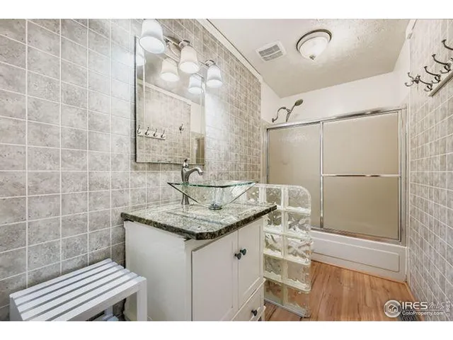 a bathroom with a granite countertop sink a toilet a mirror and shower