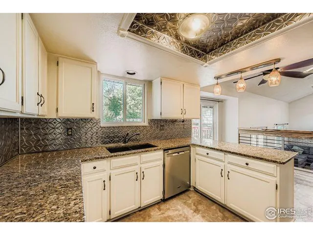 a kitchen with granite countertop a sink and cabinets