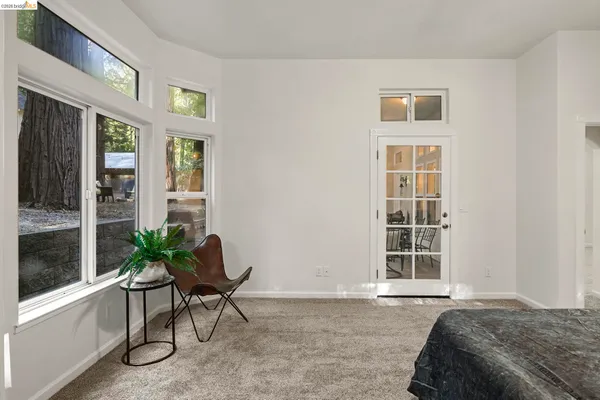 a bedroom with a bed and a chair with window