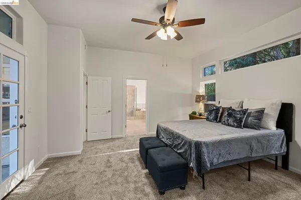 a bedroom with a bed a couch and a chandelier