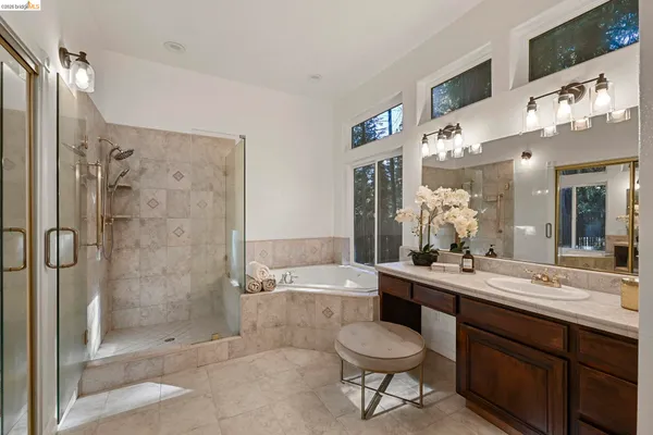 a bathroom with a bathtub shower sink mirror and toilet
