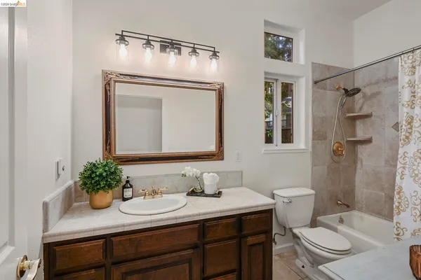 a bathroom with a granite countertop sink a toilet and a mirror