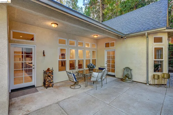 a view of a patio with table and chairs and a barbeque