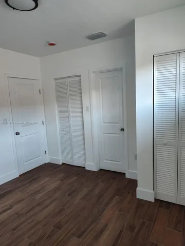 an empty room with wooden floor and closet