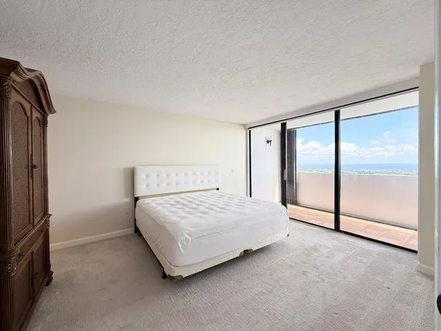 a spacious bedroom with a bed and a mirror