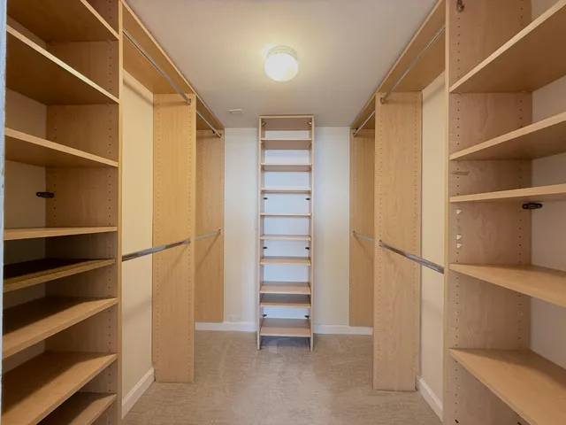 a view of walk in closet with empty racks