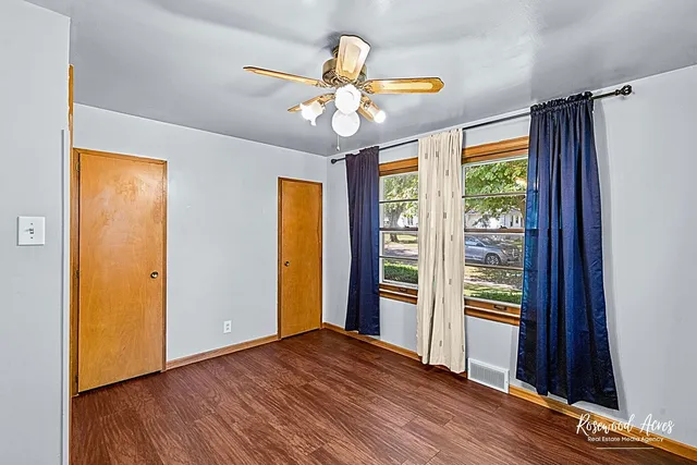 a view of an empty room with window wooden floor and a chandelier