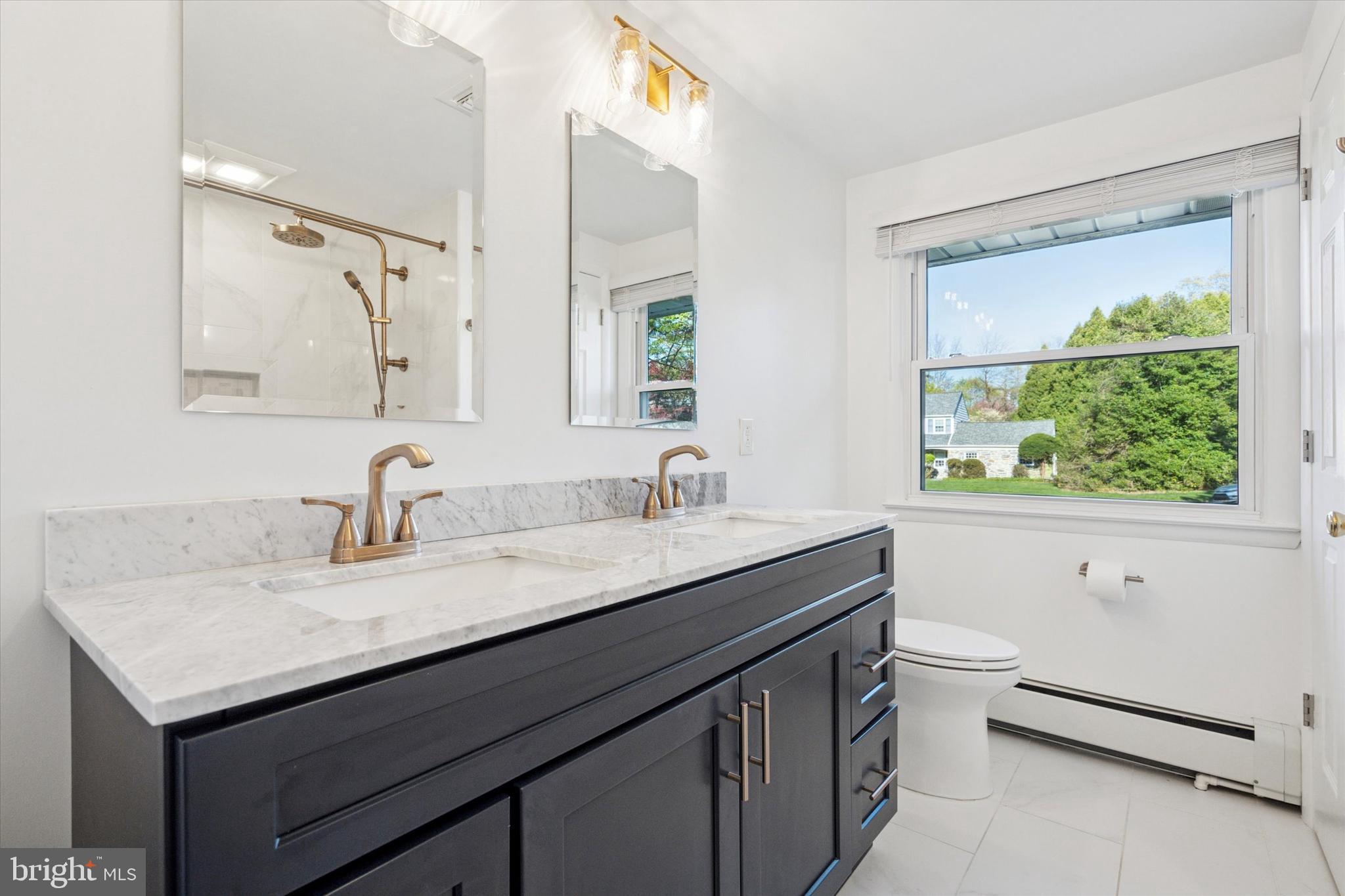 913 Penn Valley Road Media, PA 19063 - Photo 19 of 34 a bathroom with a granite countertop sink and a large mirror