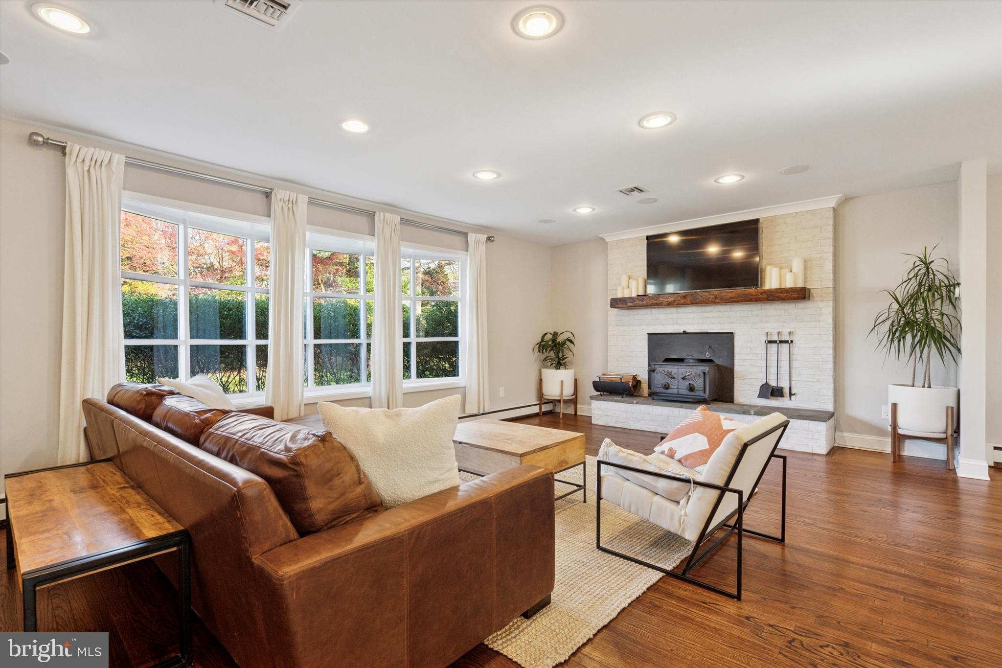 913 Penn Valley Road Media, PA 19063 - Photo 4 of 34 a living room with furniture a fireplace a flat screen tv and a large window