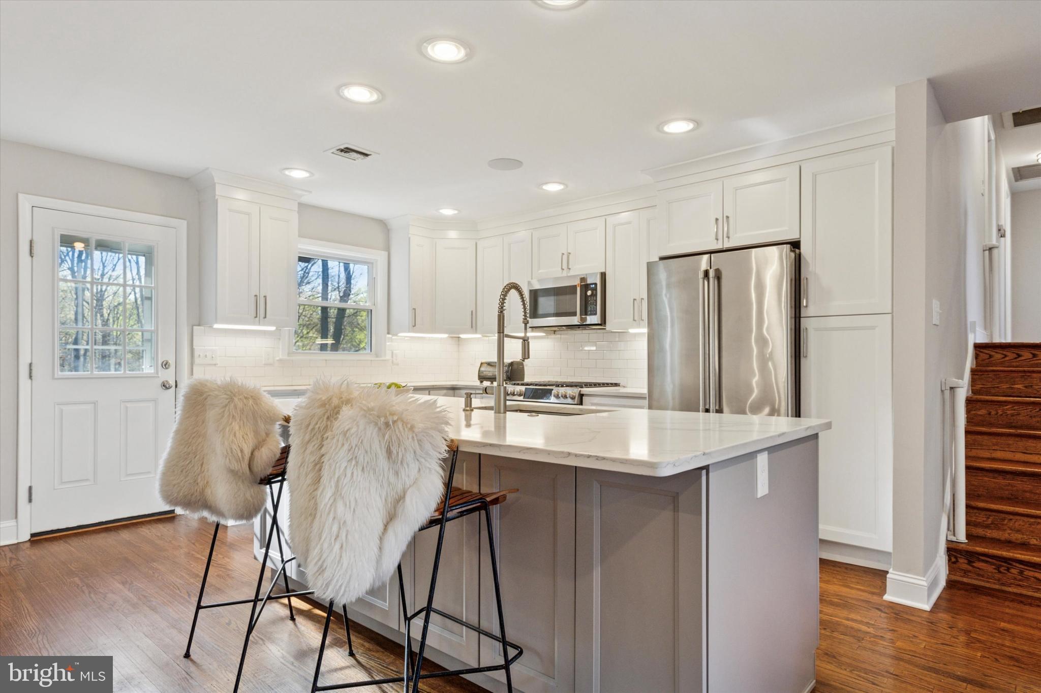 913 Penn Valley Road Media, PA 19063 - Photo 10 of 34 a kitchen with stainless steel appliances granite countertop a refrigerator a stove a sink dishwasher and a refrigerator with wooden floor