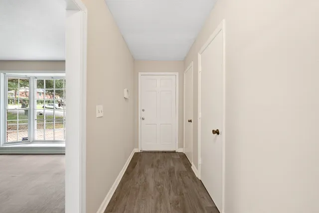 a view of a hallway with wooden floor and a window