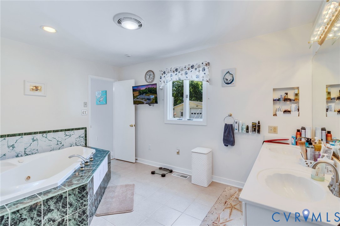 4400 Hacks Neck Road Heathsville, VA 22473 - Photo 21 of 78 a bathroom with a tub sink and mirror