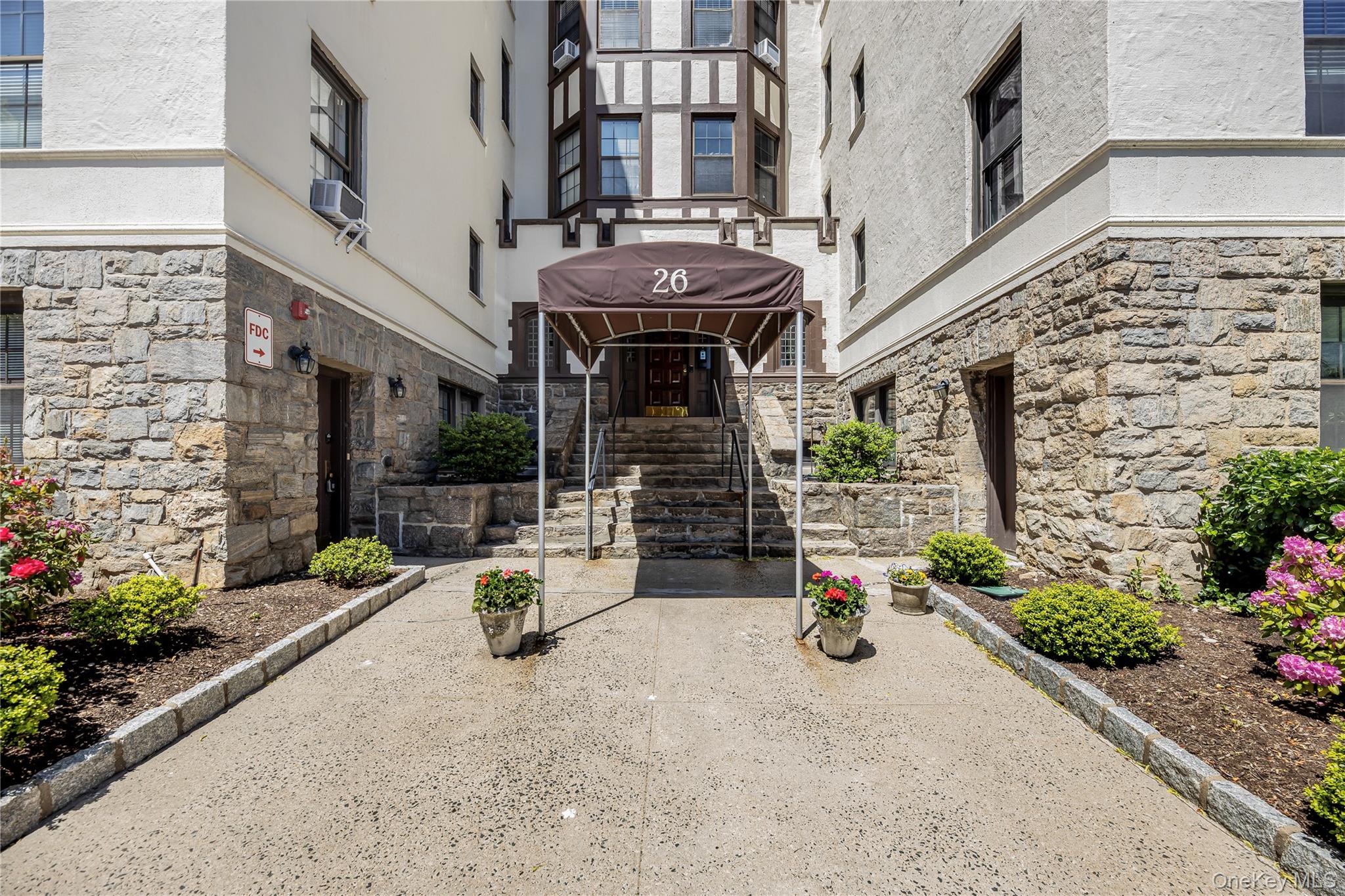 26 Pondfield Road, Unit 1D Bronxville, NY 10708 - Photo 2 of 21 an outdoor view of a building with potted plants