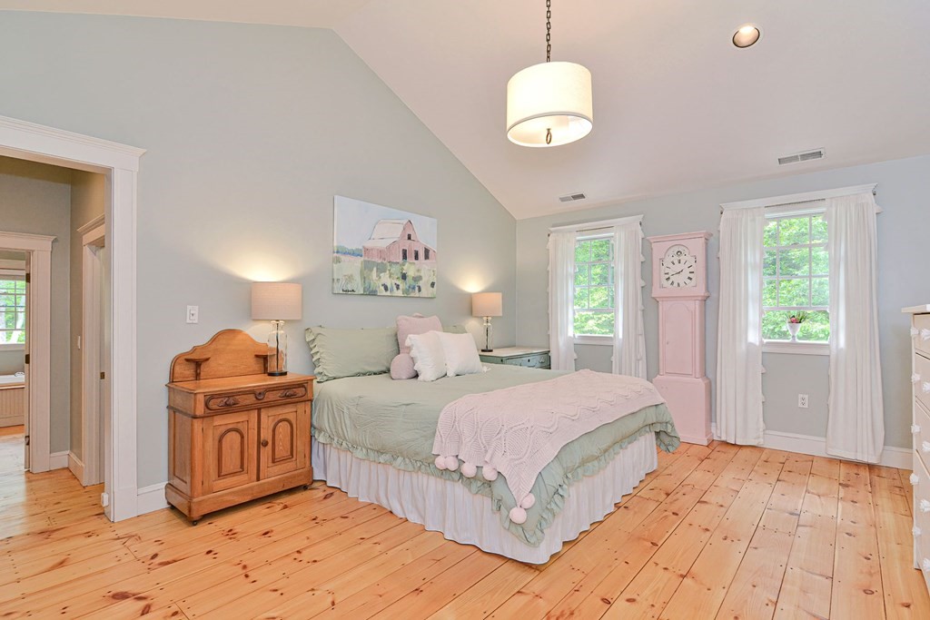 40 Brooks Station Road Princeton, MA 01541 - Photo 30 of 42 a bedroom with a large bed and a chandelier