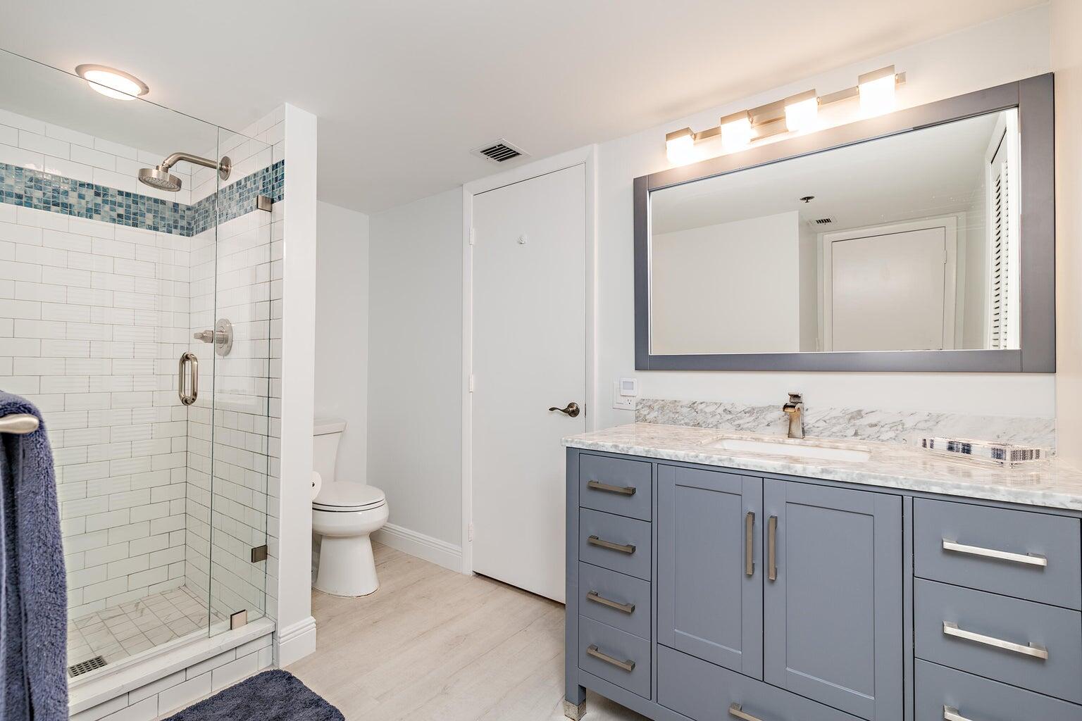 16940 Bay Street, Unit N406 Jupiter, FL 33477 - Photo 16 of 20 a bathroom with a double vanity sink toilet and shower