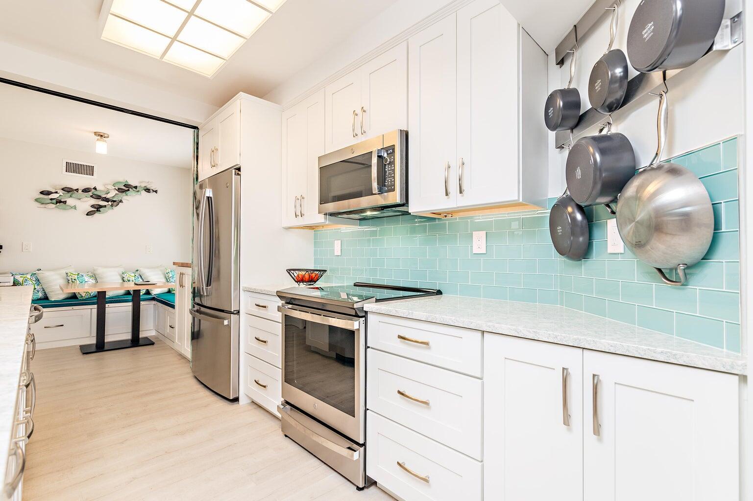 16940 Bay Street, Unit N406 Jupiter, FL 33477 - Photo 7 of 20 a kitchen with a stove and a white cabinets