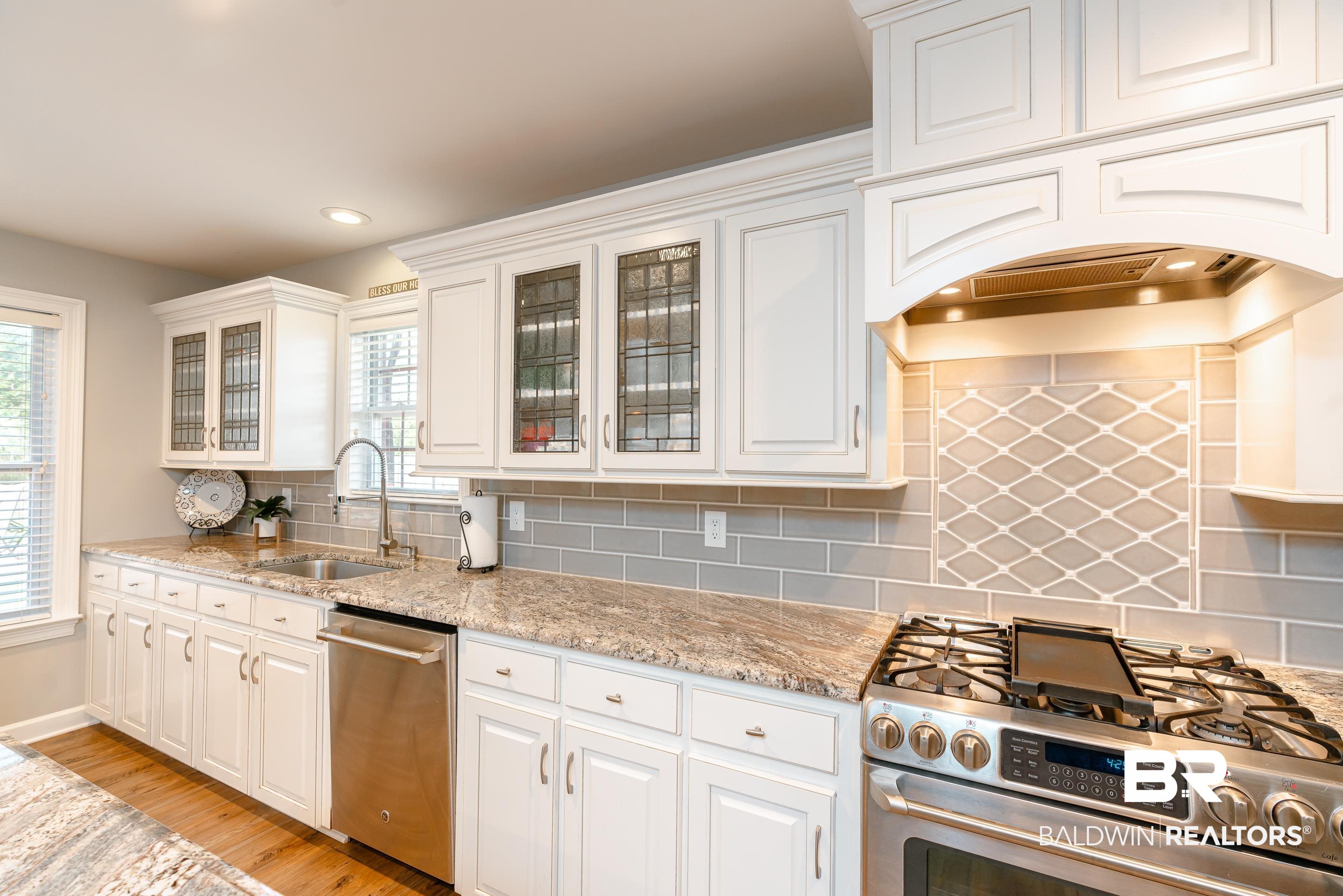 9477 Deerfield Drive Irvington, AL 36544 - Photo 11 of 58 Kitchen featuring appliances with stainless steel finishes, light hardwood / wood-style floors, decorative backsplash, and sink