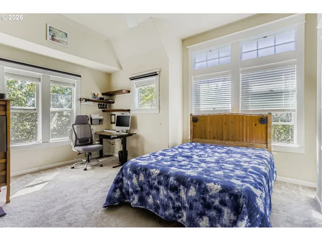 a bedroom with a bed a table and a large window
