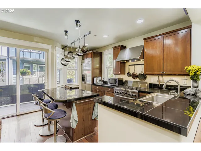 a kitchen with a table chairs stove and wooden floor