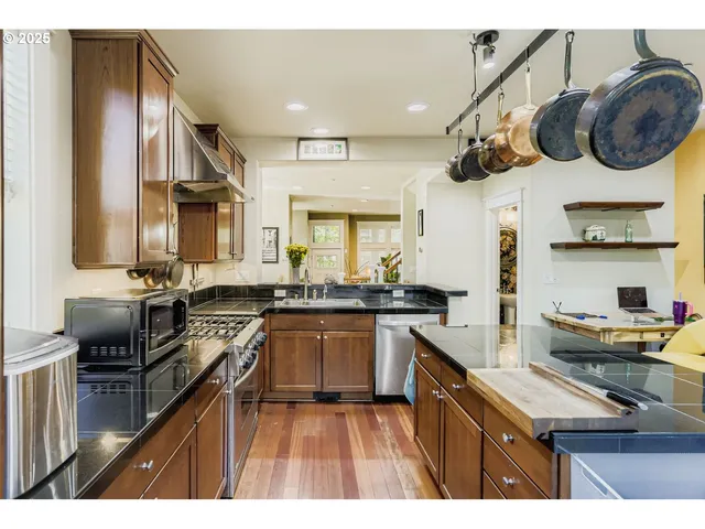 a kitchen with a sink dishwasher a stove and a refrigerator with wooden floor