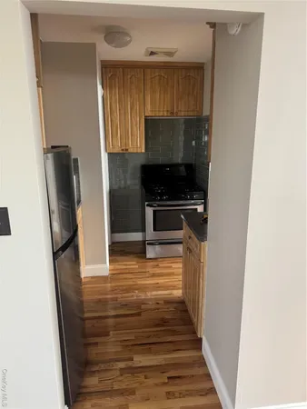 a kitchen with wooden floor and a refrigerator