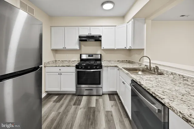 a kitchen with appliances cabinets and a stove top oven