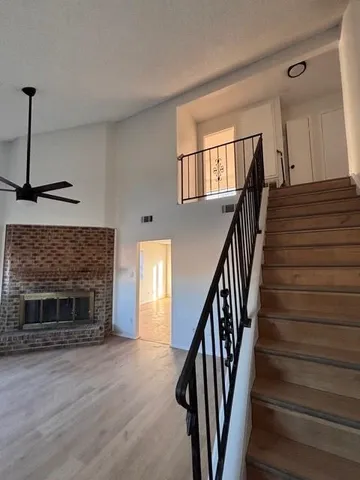 a view of hall with wooden floor and a fireplace