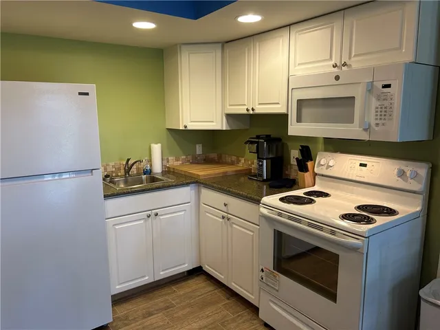 a kitchen with a refrigerator a stove a sink dishwasher and cabinets
