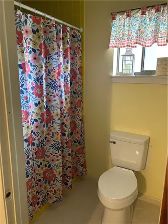 a white toilet sitting next to a shower curtain