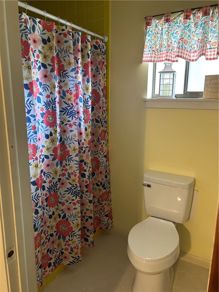9418 Fleming Grant Road Sebastian, FL 32976 - Photo 6 of 16 a white toilet sitting next to a shower curtain