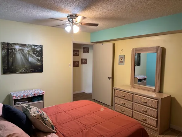 a bedroom with a bed and a mirror on the dresser