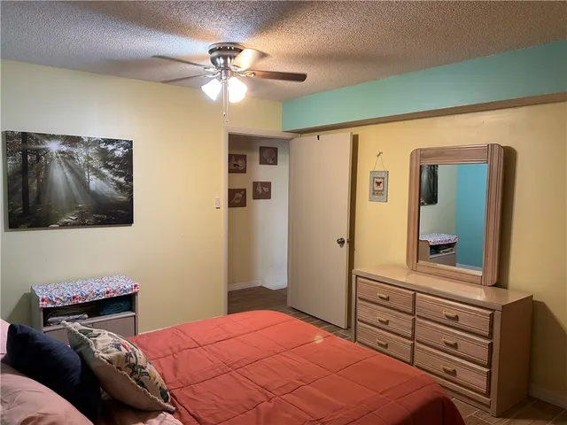 a bedroom with a bed and a mirror on the dresser