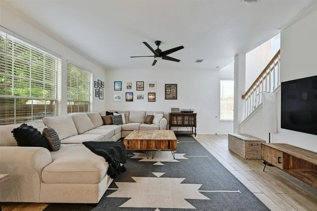 a kitchen with stainless steel appliances granite countertop a stove a refrigerator a sink dishwasher a dining table and chairs with wooden floor