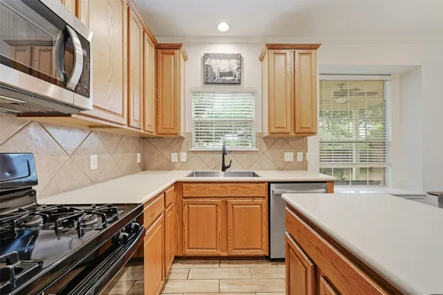 a kitchen with stainless steel appliances a stove a refrigerator and a dining table