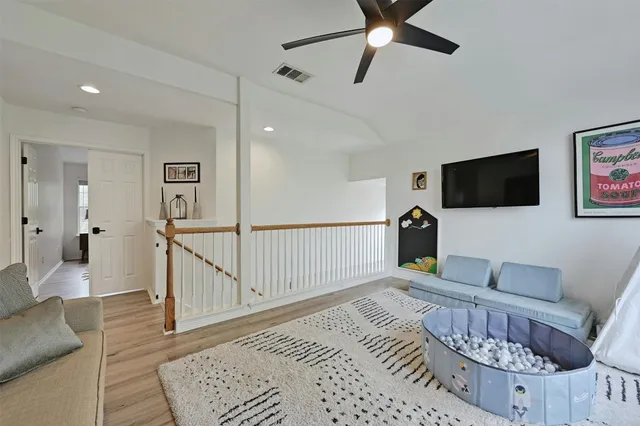 a living room with furniture and a ceiling fan