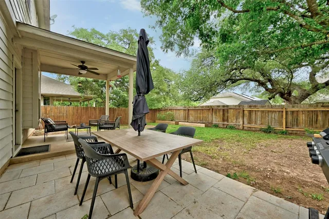 a view of a house with backyard and a tree