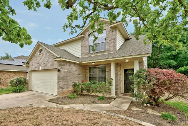 a front view of a house with a yard and potted plants