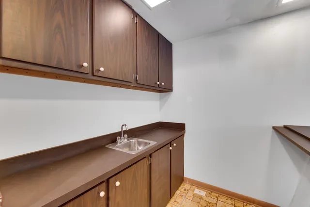a utility room with granite countertop cabinets washer and dryer