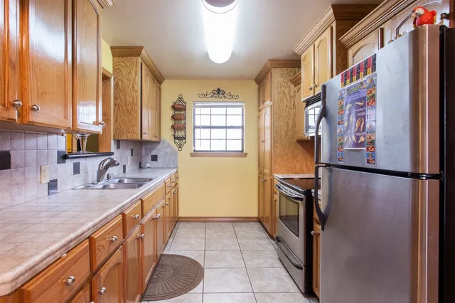 a kitchen with stainless steel appliances granite countertop a refrigerator and a sink