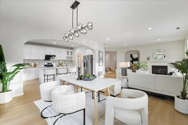 a dining room with furniture a chandelier and wooden floor