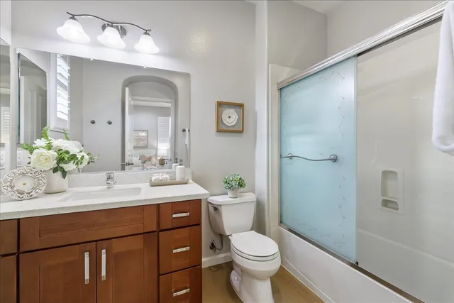 a view of a house with a small yard plants and large tree