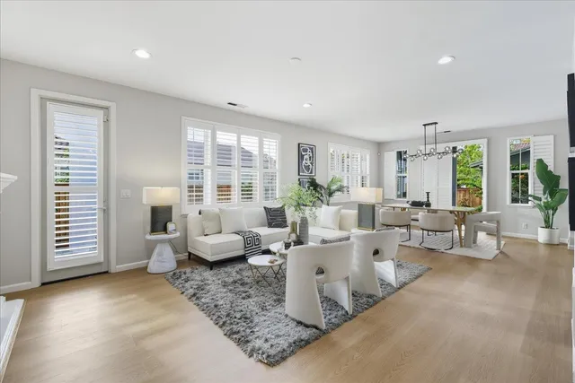 a living room with furniture potted plant and a large window