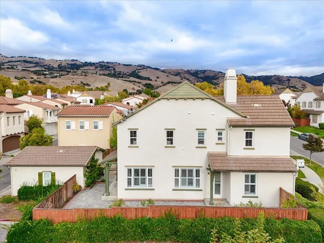 an aerial view of a city with lots of residential buildings ocean and mountain view in back