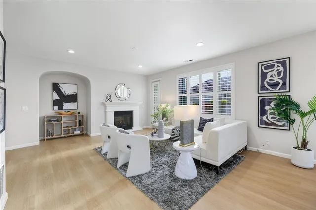 a living room with furniture a fireplace and large windows